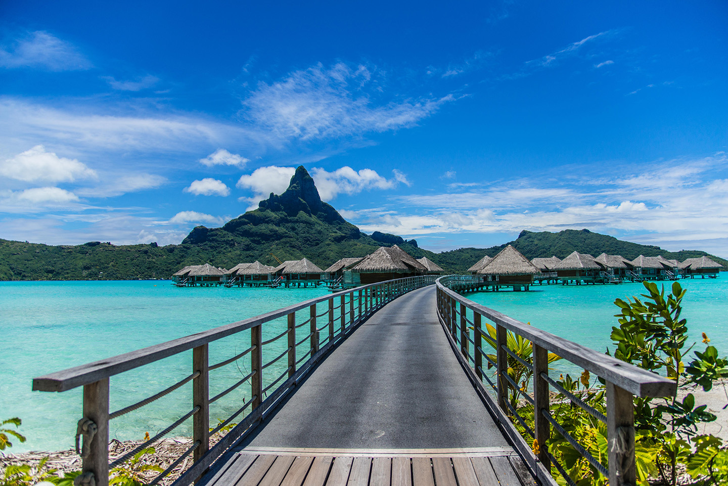 Passarela sobre a lagoa levando aos bangalôs do Four Seasons Resort Bora Bora, com o Monte Otemanu ao fundo, na Polinésia Francesa.